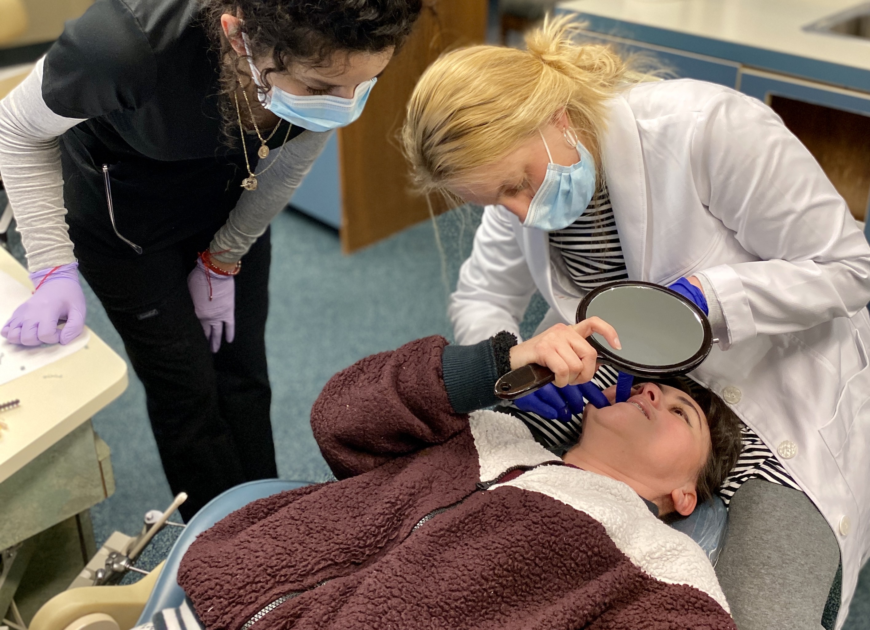 Rockwood Orthodontics team showing a patient her results with a hand mirror during a visit